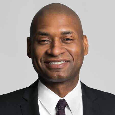 Charles Blow in a suit and tie looking forward and smiling