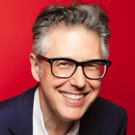 Ira Glass in glasses and wavy hair smiles
