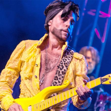 "Prince" on stage on a yellow guitar.