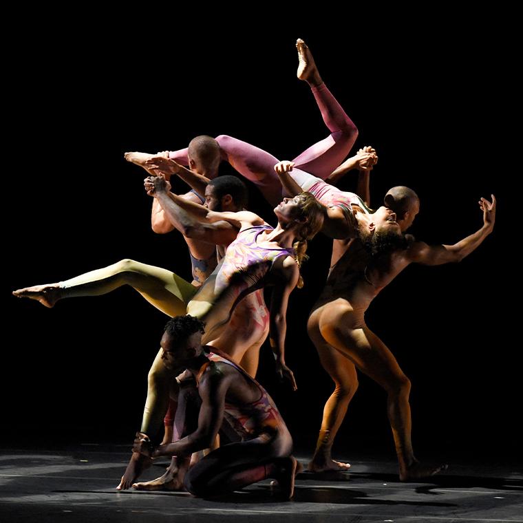 Members of Pilobolus intertwined on stage